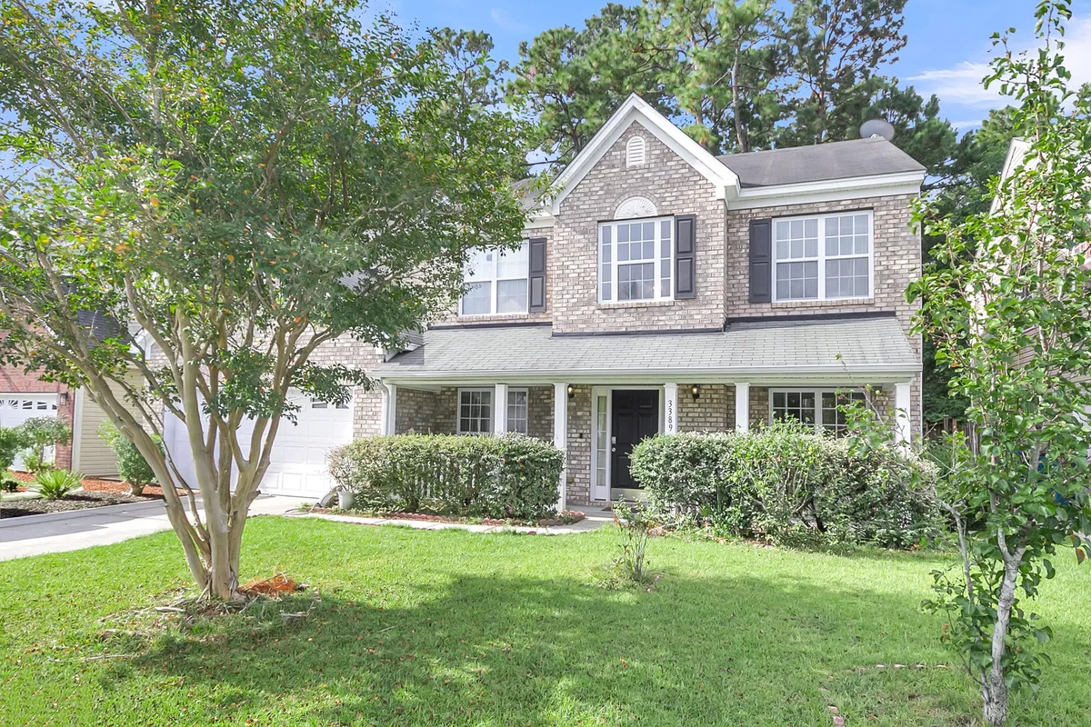 This exterior shot showcases a welcoming front porch with large windows and a landscaped garden, hinting at relaxing outdoor moments, family gatherings, and the opportunity to unwind after work. The inviting design extends the sense of comfort from the inside out.