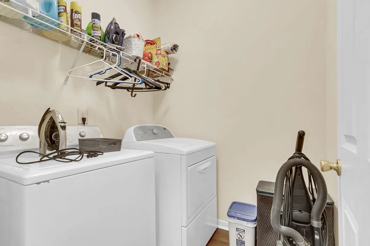 This image spotlights the in-unit laundry area, with a washing machine and dryer placed side by side and cleaning supplies nearby. The space is neat, efficient, and clearly designed for convenience.